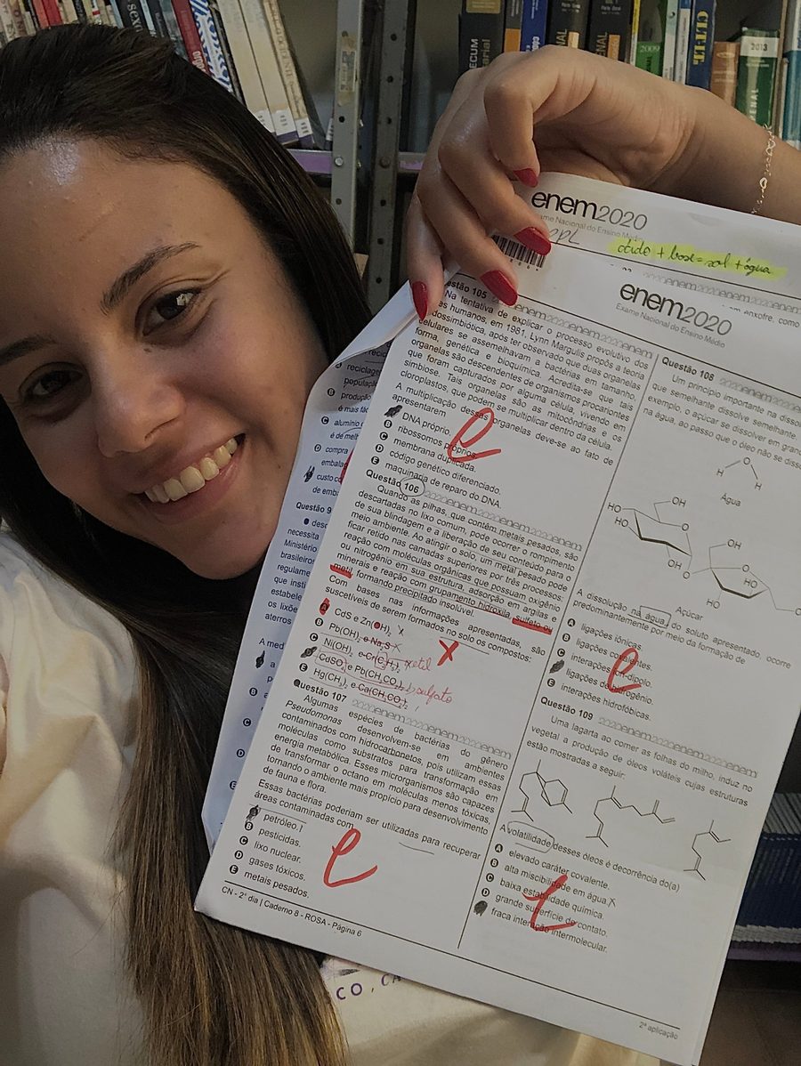Karen Viana sorrindo e segurando a prova do ENEM 2020 corrigida